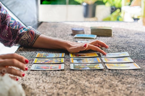 Preview: Side view of a tarot reader's hands reading the cards
