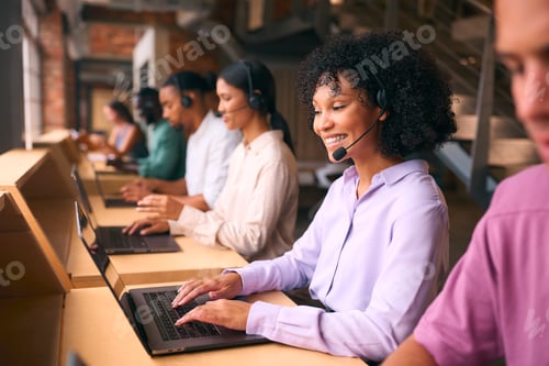Preview: Multi-Cultural Customer Support Or Telesales Team In Modern Open Plan Office Wearing Headsets