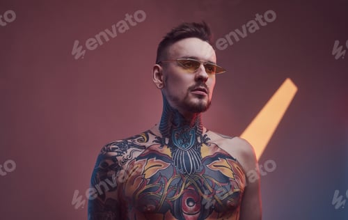 Preview: Brutal caucasian guy with tattooed body in colourful background