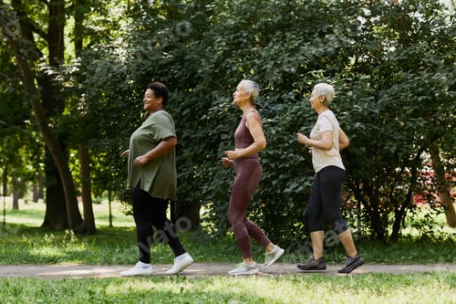 Preview: Side view active senior women jogging in park outdoors and enjoying sports