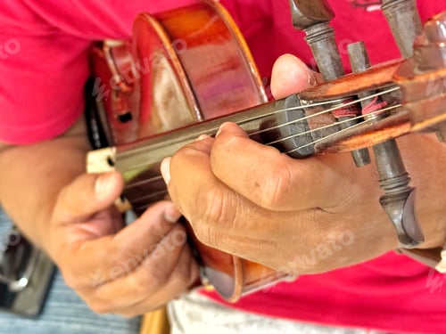 Preview: A young unrecognizable diverse musician quietly practices violin while waiting to perform on stage