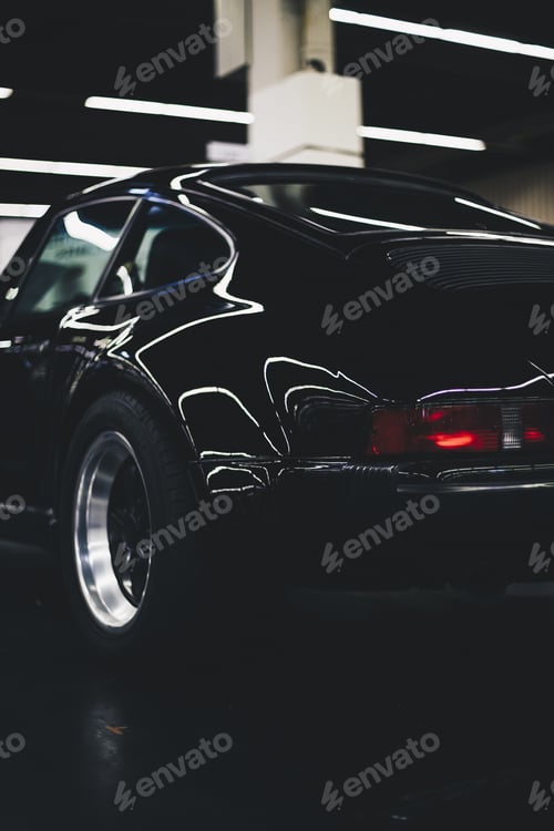 Preview: Vertical shot of a parked black car with a blurry background