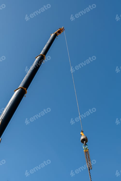 Preview: Jib crane boom crane arm against blue sky background at construction zone