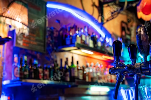 Preview: Close-up photo of beer tap at a bar with colorful neon lights.