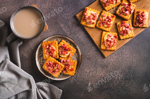 Preview: Spicy baked crackers with cheese and sausage on a plate on the table top view