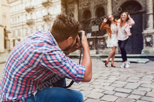 Preview: Young Man Photographer Taking Pictures, Holding Digital Photo Camera, Girls Posing On Background