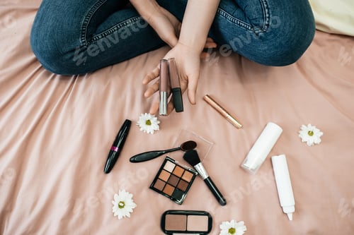 Preview: Woman With Makeup and Cosmetics on Bed