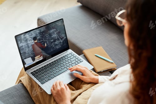 Preview: Woman Watching Online Lecture on Laptop at Home