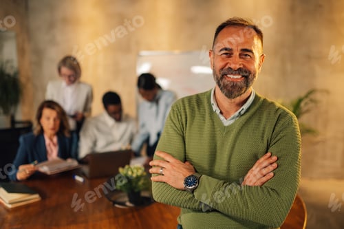 Preview: Mature executive posing at boardroom on meeting of interracial team.