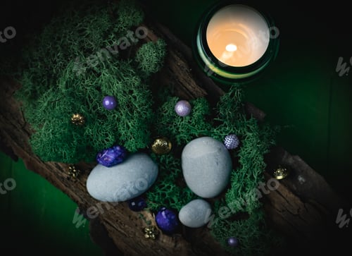 Preview: Lilac, golden stone in the bark of a tree with green moss, gray stones and a burning candle