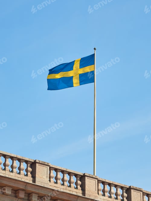 Preview: The national flag of Sweden on building against the blue sky.