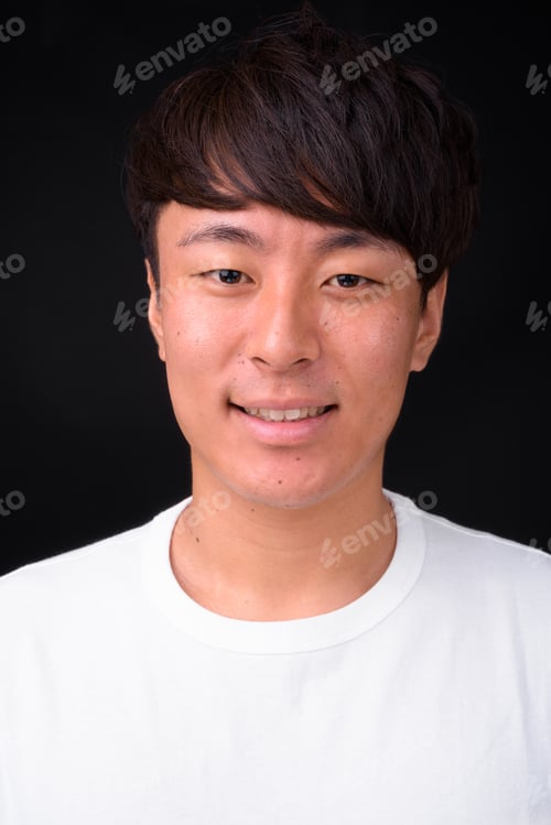 Preview: Young handsome Asian man against black background