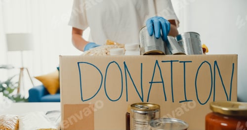 Preview: girl volunteer wear gloves packing food and drinks donation into donations paper boxes while working