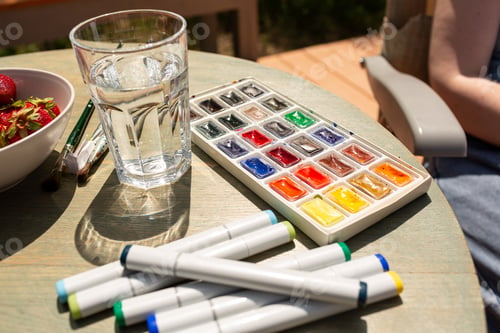 Preview: Watercolor granules, paints, watercolor markers, a set of brushes and a glass of water for drawing