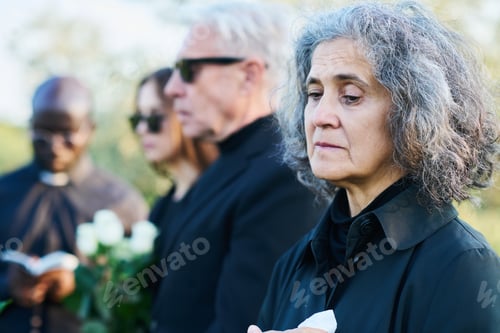 Preview: Mature grieving woman in mourning clothes standing in front of camera