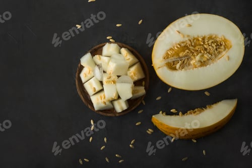 Preview: Half cut and slices melon on black table