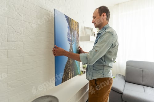 Preview: man holds canvas in the interior