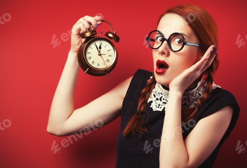 Preview: Surprised redhead girl with clock.
