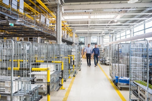 Preview: Two men walking in factory shop floor