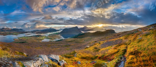 Preview: Panoramic shot of grassy hills and mountains near water under a blue cloudy sky in Norway