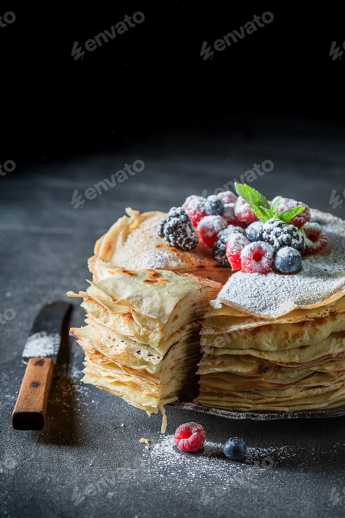 Preview: Closeup of stack of pancakes with fresh berries and sugar