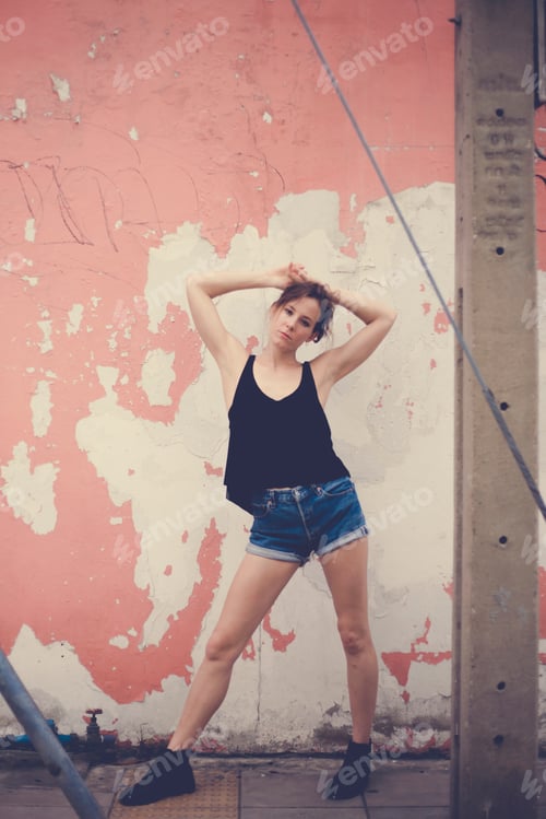 Preview: Young caucasian woman posing in front of the wall