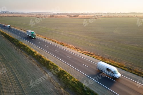 Preview: Aerial view of cargo trucks driving on highway hauling goods.