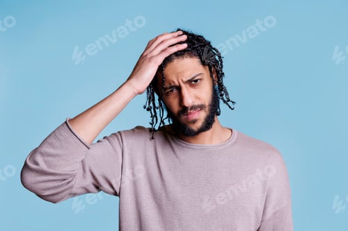 Preview: Tired arab man having headache and looking at camera