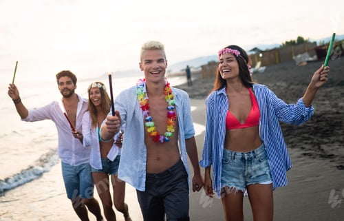 Preview: Group of happy friends having fun walking down the beach at sunset