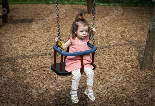 Preview: Portrait of a little girl riding on a swing.