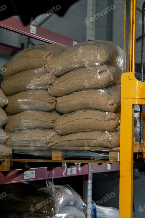 Preview: a worker at a coffee factory uses a yellow forklift to lift and place a pallet on shelf