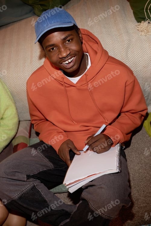 Preview: Smiling Young Man Wearing Blue Cap Holding Notepad