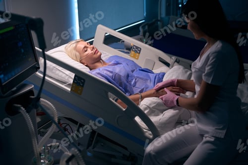 Preview: Nurse communicates with a patient after surgery in hospital room