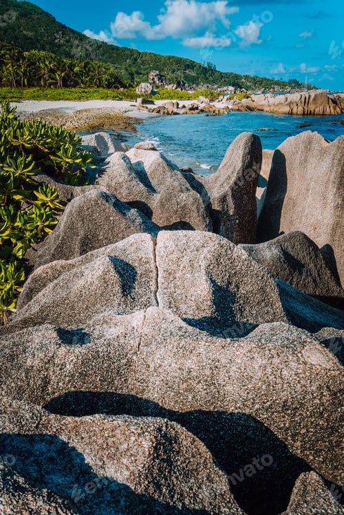 Preview: Unique big granite rocks in lush green foliage on hidden picturesque tropical coastline. Grand L