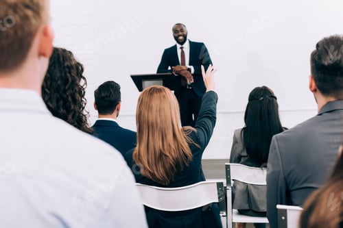 Preview: african american lecturer talking to audience during seminar in conference hall, participant raising