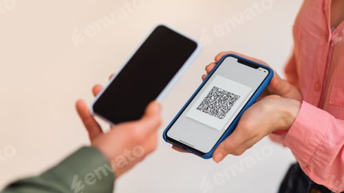 Preview: Man Using Phone Scanning QR Code On Cellphone Indoor, Cropped
