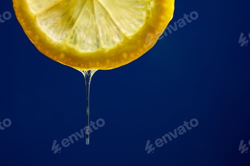 Preview: Fresh slice of lemon juice drip on blue background, citrus