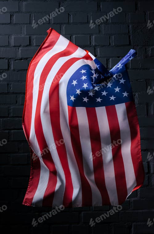 Preview: vertical waving united states flag in front of black brick wall, Independence Day concept