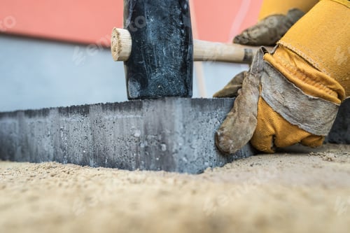 Preview: Workman installing paving stones or bricks