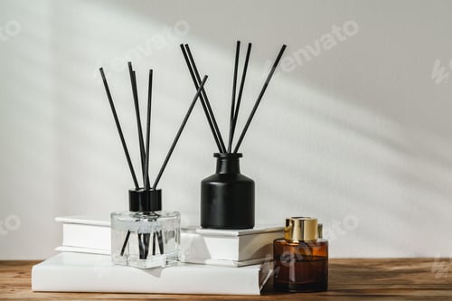 Preview: Aromatic Reed Diffuser on White Books With Shadows Playing on the Wall