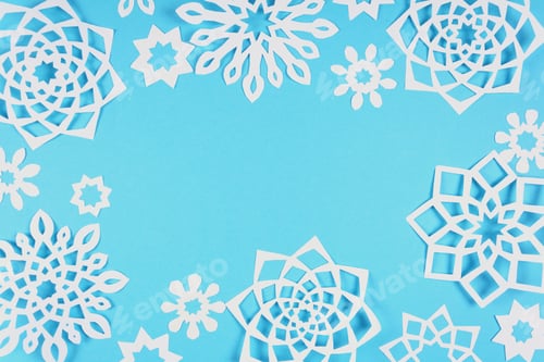 Preview: Paper snowflakes on blue background. Top view. Christmas decoration. Toned