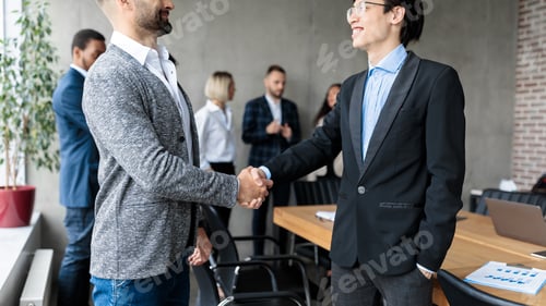 Preview: Two Businessmen Shaking Hands After Successful Negotiations In Office