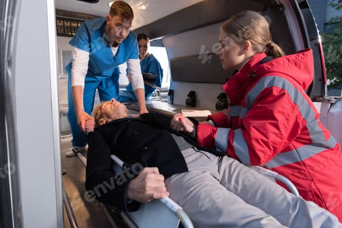Preview: paramedics moving wounded mature man into ambulance on stretcher