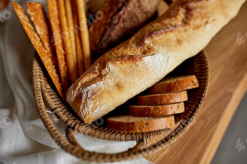 Preview: Top view of various kinds of bread on a wooden surface.