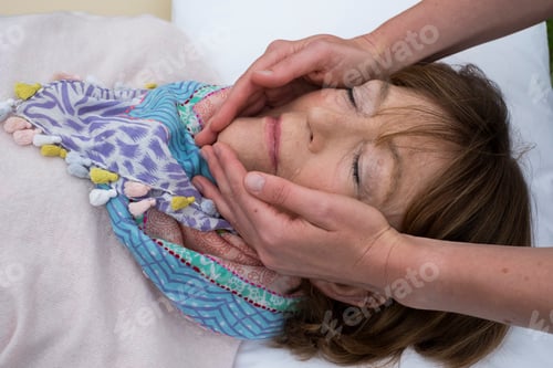 Preview: Therapist holding her hands on both sides of a client's face.