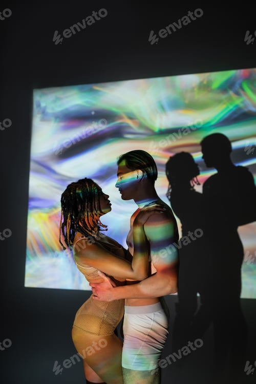 Preview: side view of young, shirtless and muscular man embracing appealing african american woman with