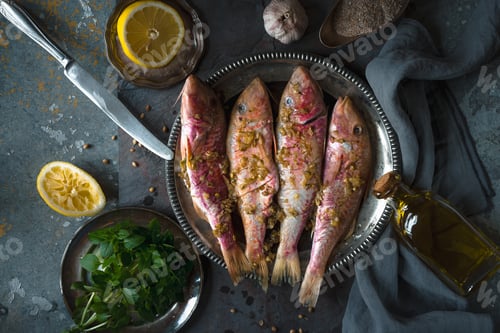 Preview: Plate of fried small fish red mullet and olive oil