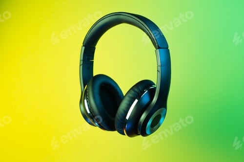 Preview: Black stylish modern wireless headphone in neon lights over colorful background.