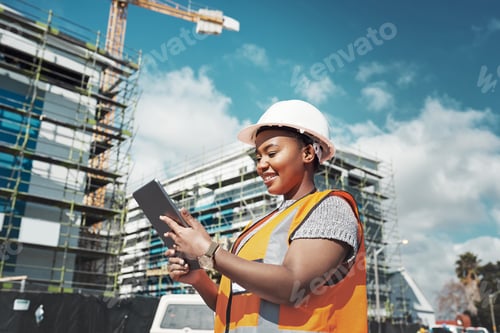 Preview: Shot of a young woman using a digital tablet while working at a construction site