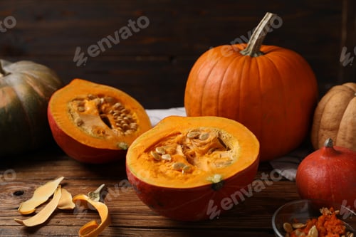 Preview: Fresh pumpkins, seeds and peel on wooden table, closeup